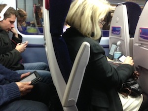 It's so funny - how we don't talk any more. Photo of texting on train